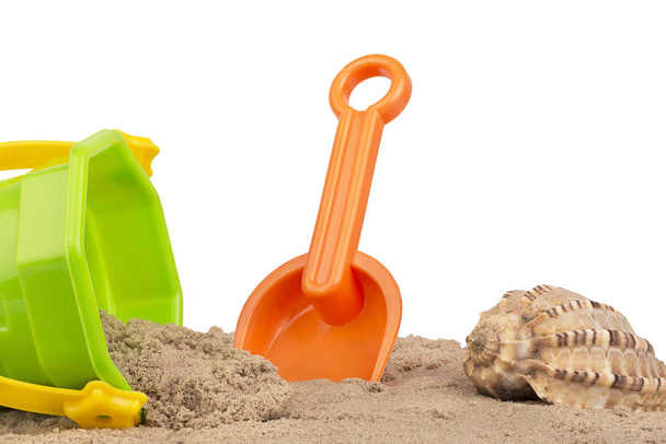 Wiadro i łopata zabawki na plaży, na białym tle. Miejsce dla tekstu lub obrazu. - Zdjęcie, obraz