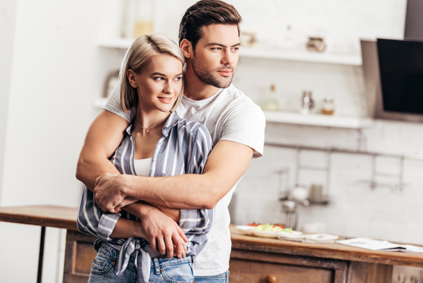novio guapo y novia atractiva abrazándose en la cocina
 - Foto, imagen