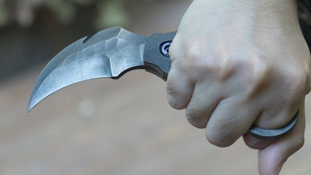 Μαχαίρι στα χέρια, karambit τακτικής μαχαίρι μαχητής, αυτοάμυνα και πολεμικές τέχνες καταπολέμηση - Φωτογραφία, εικόνα