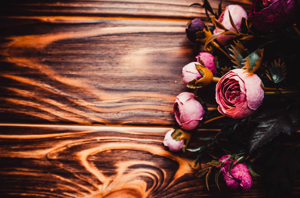 Ροζ λουλούδια σε καφέ ξύλινο φόντο - Φωτογραφία, εικόνα