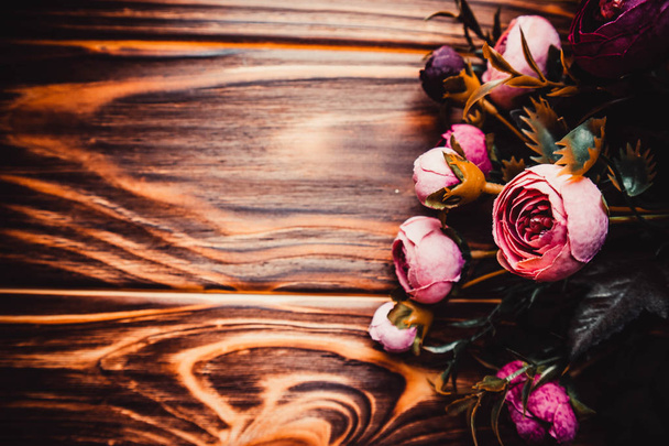 Pink flowers on brown wooden background - Foto, afbeelding