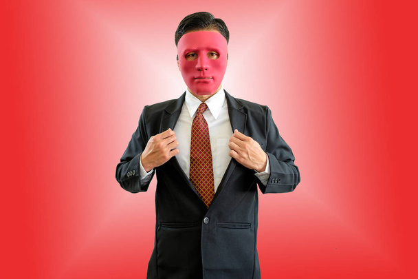 Geschäftsmann mit roter Maske auf rotem Hintergrund mit Schneideweg. - Foto, Bild