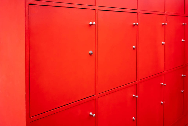 Красная раздевалка с закрытыми дверями. Бесплатные услуги в фитнес или школе
. - Фото, изображение