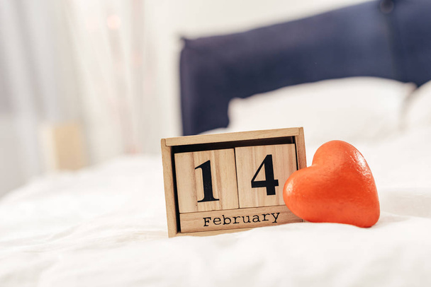 2 月 14 日レタリングとバレンタインの日に赤いハート グッズ木製カレンダーの選択と集中 - 写真・画像