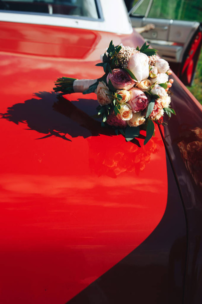Bridal bouquet on the hood of the car - Photo, image