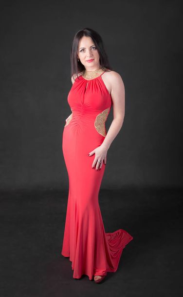 studio portrait of a woman in a long red dress - Фото, изображение