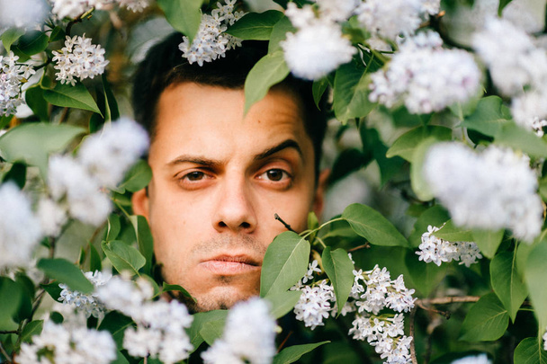 Retrato de close-up de homem jovem em belos arbustos lilás
 - Foto, Imagem