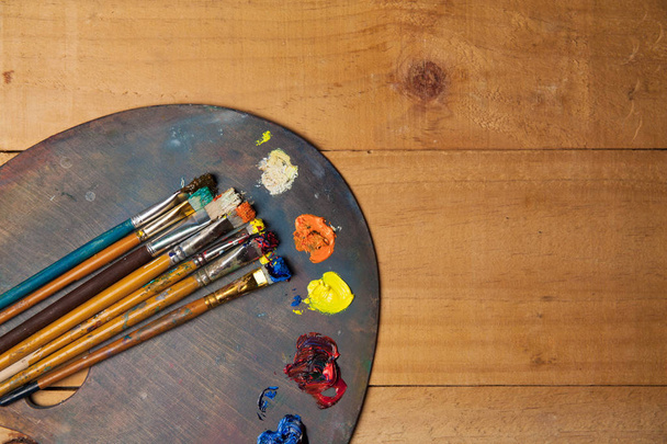 Tavolozza di colori con pennelli su sfondo di legno
   - Foto, immagini