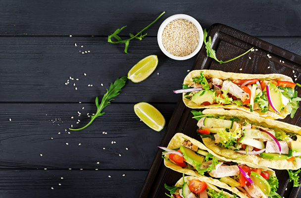 Μεξικάνικα τάκος με κρέας κοτόπουλου, αβοκάντο, ντομάτα, αγγουράκι και κόκκινο κρεμμύδι. Υγιή τορτίγια. Τυλίγουμε το φαγητό. Taco. Το Top view - Φωτογραφία, εικόνα