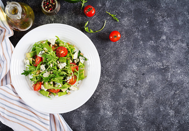 Dietary salad with tomatoes, blue cheese, avocado, arugula and pine nuts. Top view. Flat lay. - Foto, immagini