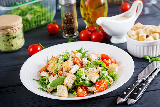 Healthy grilled chicken Caesar salad with tomatoes, cheese and croutons. North American cuisine - Фото, изображение