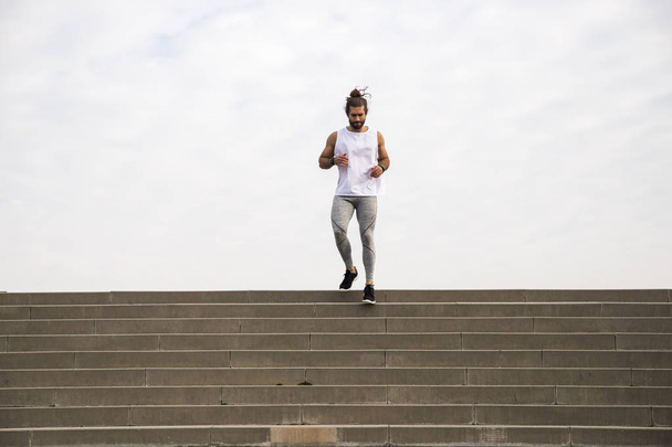 Mladý muž běží dolů po schodech na ranní trénink  - Fotografie, Obrázek