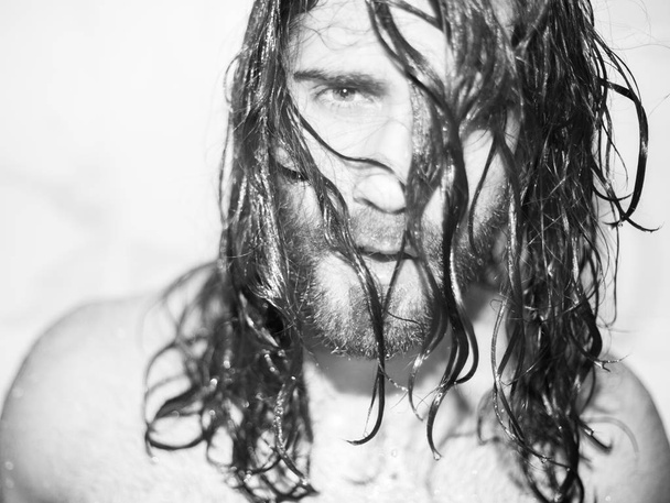 портрет молодого бородатого человека с влажными длинными волосами
 - Фото, изображение