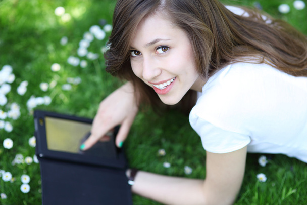 Жінка використовує цифровий планшет на відкритому повітрі
 - Фото, зображення