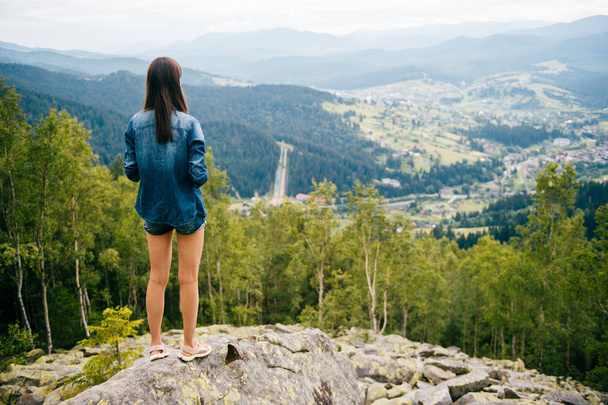 back view of lonely young traveller with beautiful mountains on background - Photo, Image