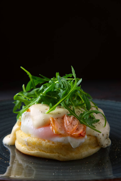 Sandwich with poached egg, smoked salmon and cheese decorated with arugula - Fotó, kép