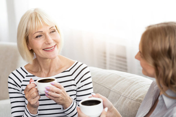 Mature mother and her daughter drinking coffee - Foto, immagini