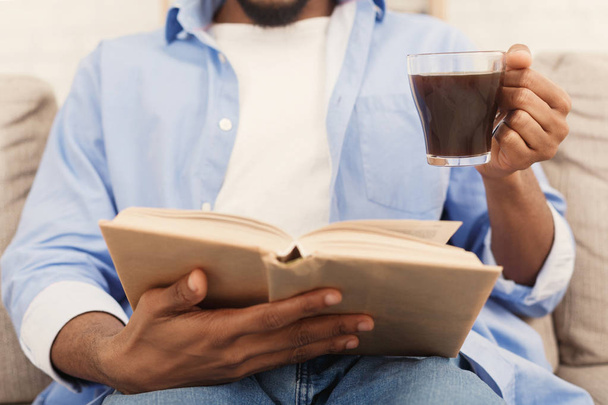 Jovem homem afro-americano lendo livro em casa
 - Foto, Imagem