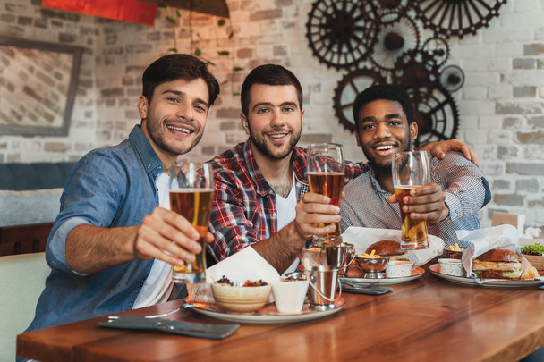 Bier trinken mit Freunden. Männer sitzen zusammen in Bar - Foto, Bild