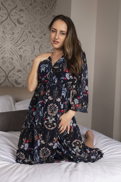 Petite young brunette in a long midnight blue print dress - Foto, afbeelding
