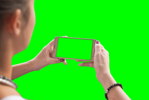 Girl watching a video or play game on a mobile phone. Chroma key isolated. - Foto, Imagen