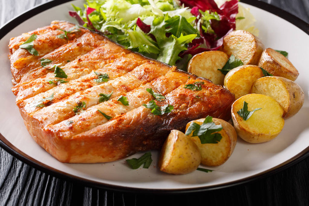 pesce spada grigliato con contorno di patate fritte e insalata fresca primo piano su un piatto su un tavolo di legno. orizzonti
 - Foto, immagini
