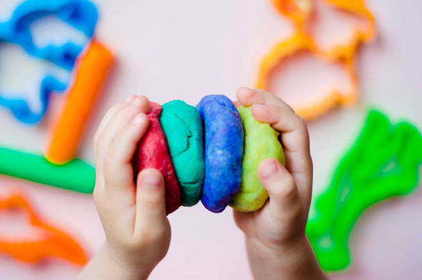 Main d'enfant jouant avec de l'argile colorée. plastiline maison
 - Photo, image