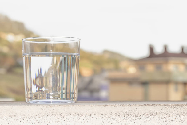 街の背景に澄んだ水のガラス - 写真・画像