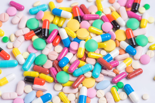 Pilules ou capsules vertes et jaunes sur fond blanc
 - Photo, image