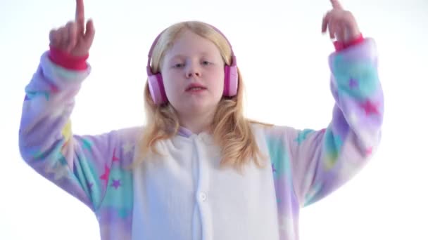 moda moderna - hermosa chica rubia escucha música con auriculares y bailando sobre un fondo blanco en pijama kigurumi - aislado en blanco
 - Metraje, vídeo