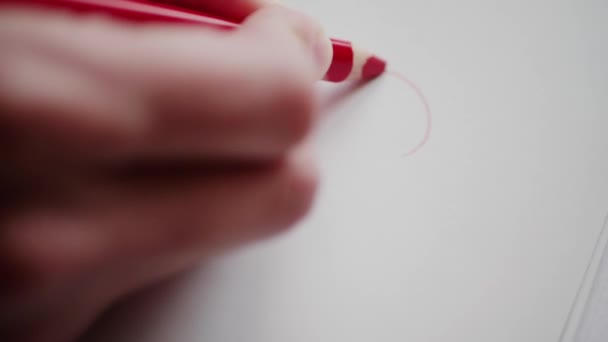 Right hand drawing red heart contour by pencil for sweetheart at Valentine's day. Outlining heart in love message. Hand adumbrating Valentine heart on handmade card as romantic symbol. Happy Valentine's day. Preparing Valentine gift for adored person - Footage, Video