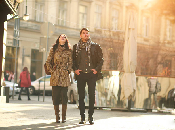 Young dreamy couple carefree walking along the streets of the old city at sunset - Photo, image
