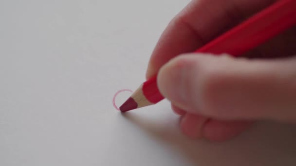 Right hand drawing small red heart by pencil for sweetheart at Valentine's day. Outlining heart in love message. Hand adumbrating Valentine heart on handmade card as romantic symbol. Happy Valentine day - Footage, Video