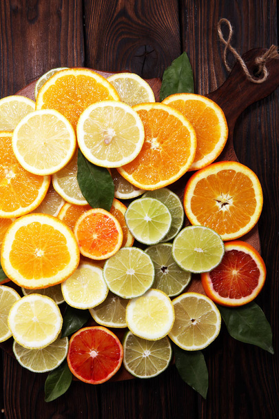 Citrusfélék, a narancs, a citrom, a grépfrút és a lime, barna háttér. - Fotó, kép