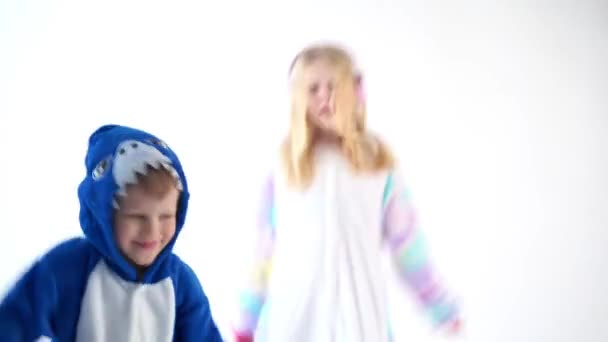 niños bailando divertido sobre un fondo blanco en pijama kigurumi
 - Imágenes, Vídeo