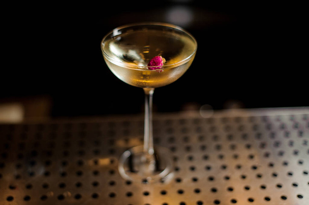 Elegant glass filled with tasty sweet cocktail decorated with rose bud - 写真・画像