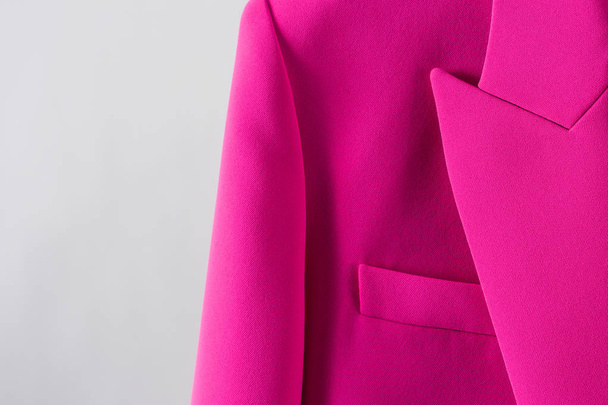 Mooie roze vest op witte achtergrond. Closeup zak en revers. Stijlvolle moderne kleding. - Foto, afbeelding