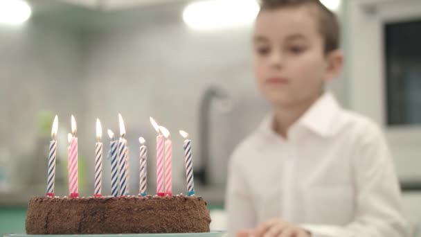 Chico mirando pastel de cumpleaños con llamas de velas. Feliz cumpleaños concepto
 - Imágenes, Vídeo