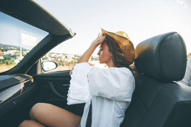 View at young attractive woman driving in cabriolet at seaside - Foto, Imagem