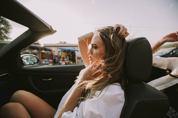 白のカブリオレの車で運転、自由と楽しみを探している 2 つの幸せの女性の友人 - 写真・画像
