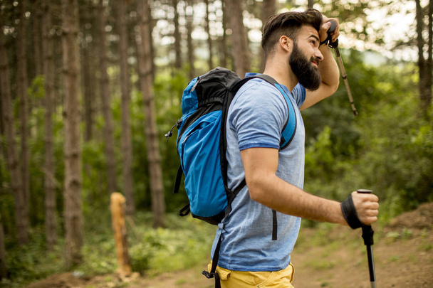 Side view at young handsome bearded hiker in mountain - Photo, Image
