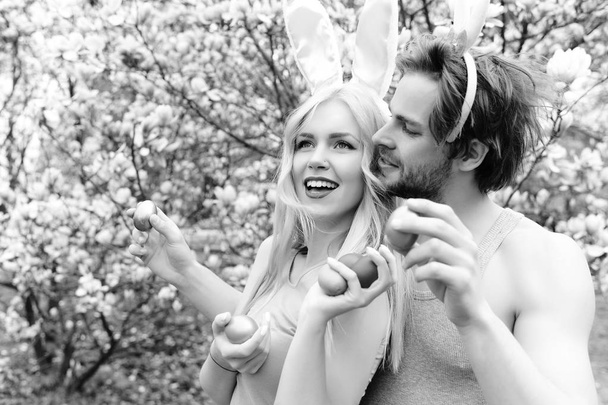 girl and handsome man with bunny ears holding eggs - Fotoğraf, Görsel
