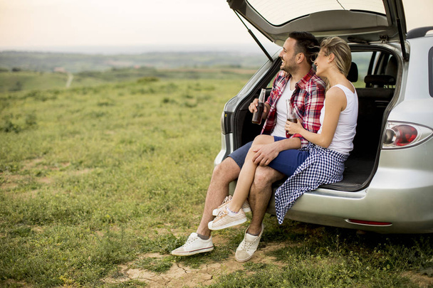 Miłości para siedzi w trank samochodu podczas podróży w przyrodzie - Zdjęcie, obraz