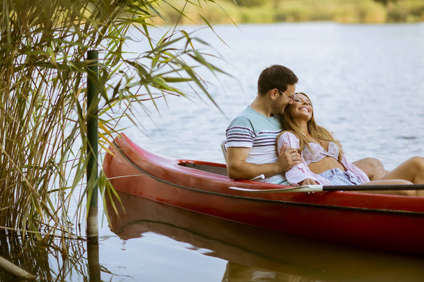 Loving couple rowing on the calm lake at summer day - Φωτογραφία, εικόνα
