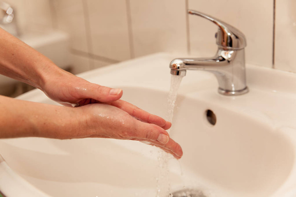Mulher lavar as mãos no banheiro
 - Foto, Imagem