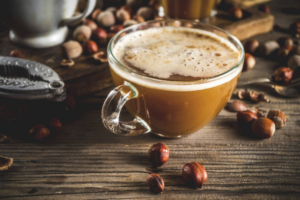 Ev yapımı fındık kahve latte veya kapuçino, rustik ahşap arka plan ile fındık, 3 kahve fincanı alanı kopyalama - Fotoğraf, Görsel