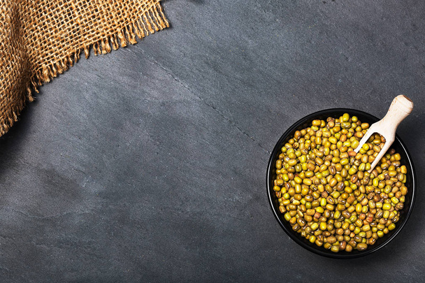Raw Moong Dal legumes on gray concrete background with copy space for your text. Top view of selected healthy and clean foods. Superfoods concept. - Фото, зображення