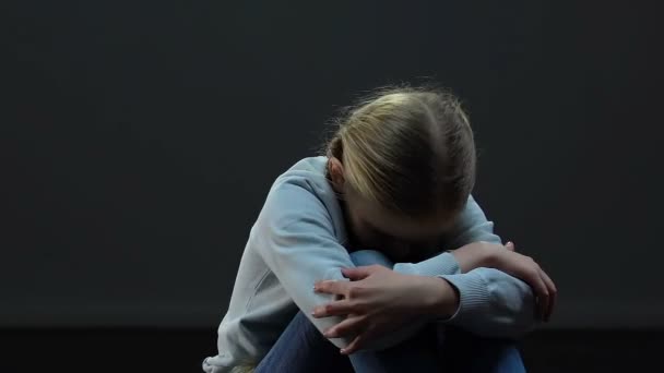Przestraszony, mała dziewczynka samotny siedzący w pustym, ciemnym pokoju, kara, maltretowania - Materiał filmowy, wideo