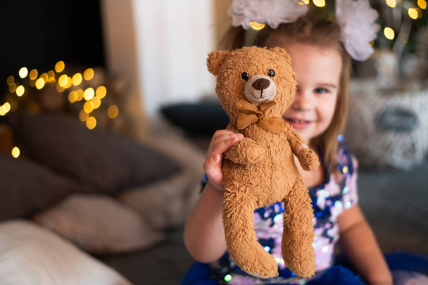 Cheerful little girl playing with her fluffy toy - Фото, зображення