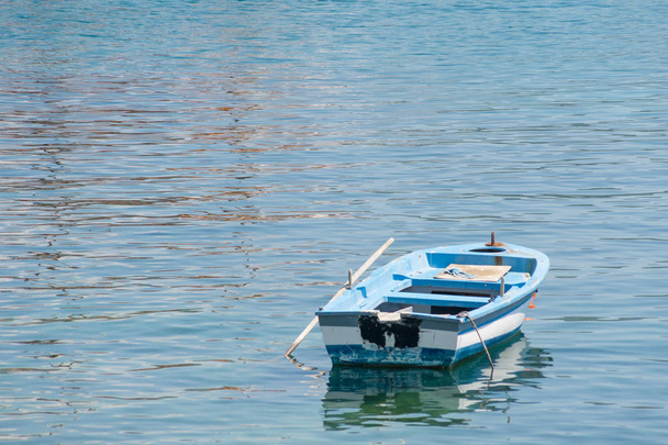 Невеликі білі синій човен з весла на якір на березі. - Фото, зображення